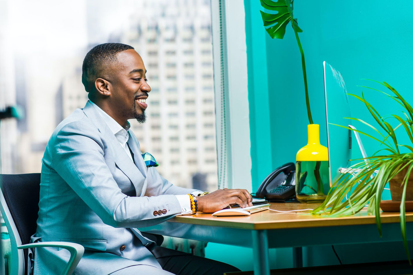 Homme noir à son bureau regardant son écran d'ordinateur
