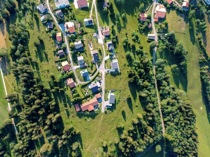 Vue aérienne d'un village entourés de champs et de bois