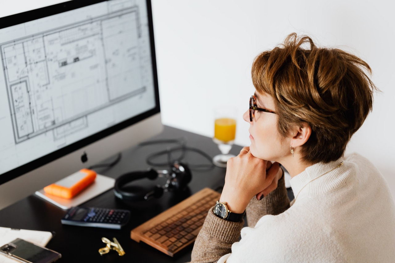 Woman sitting at her desk in front of the monitor of her computer