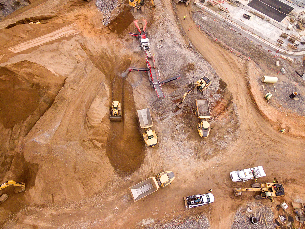 Vue aérienne d'un terrain sablonneux sur lequel se trouvent des véhicules de construction