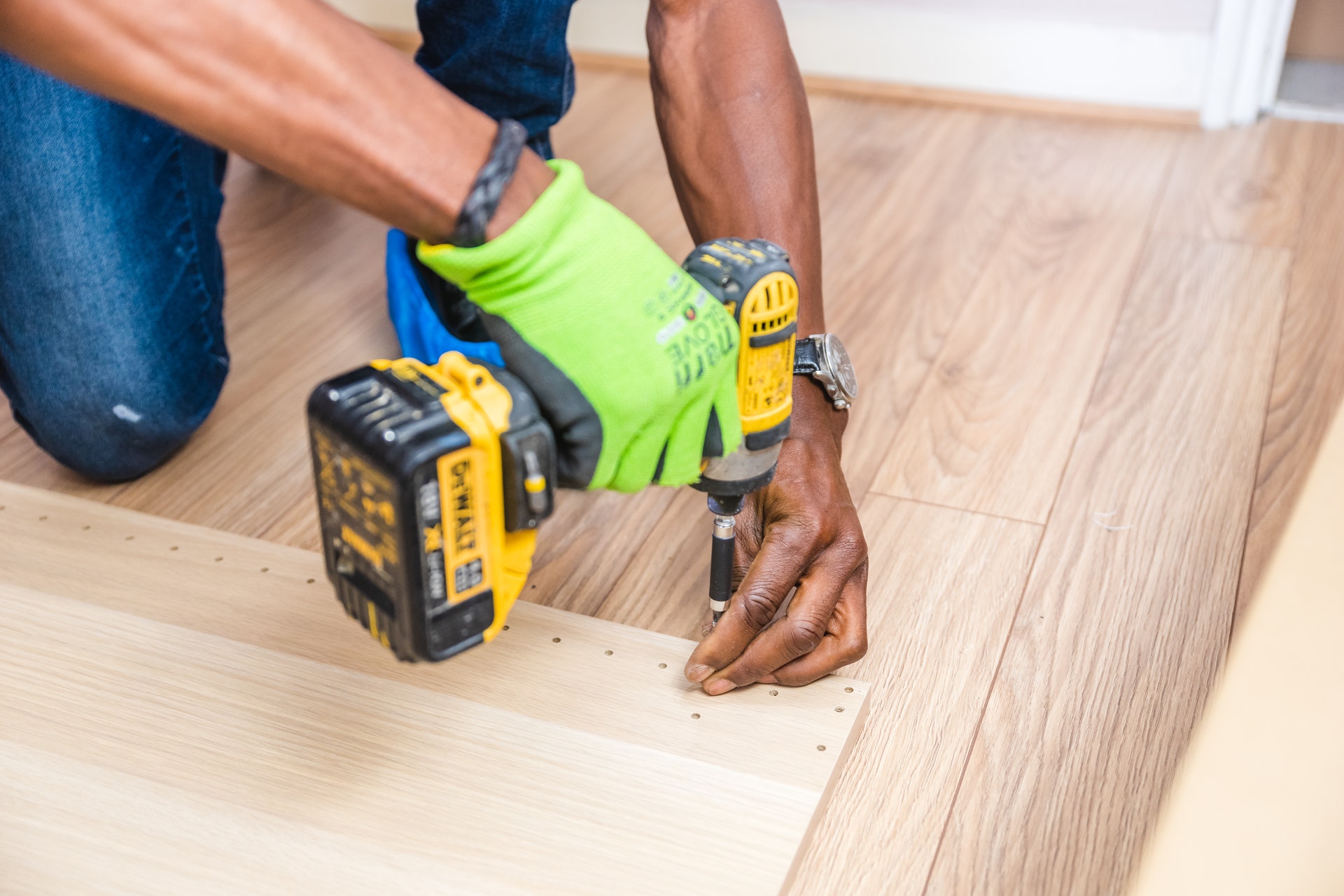 Gros plan des mains d'une personne noire utilisant une perceuse