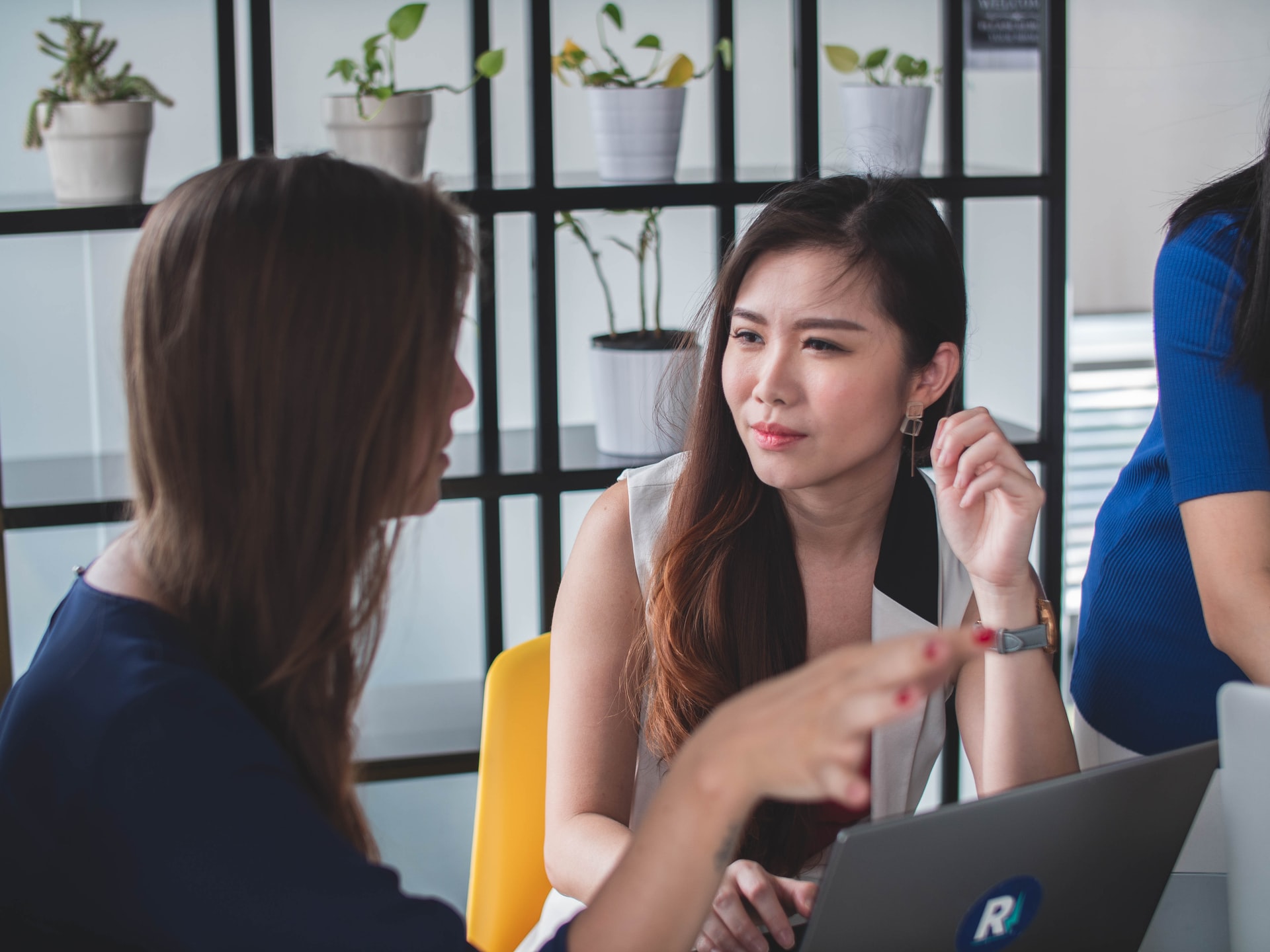 Uen femme asiatique écoute parler une autre femme assise en face d'elle