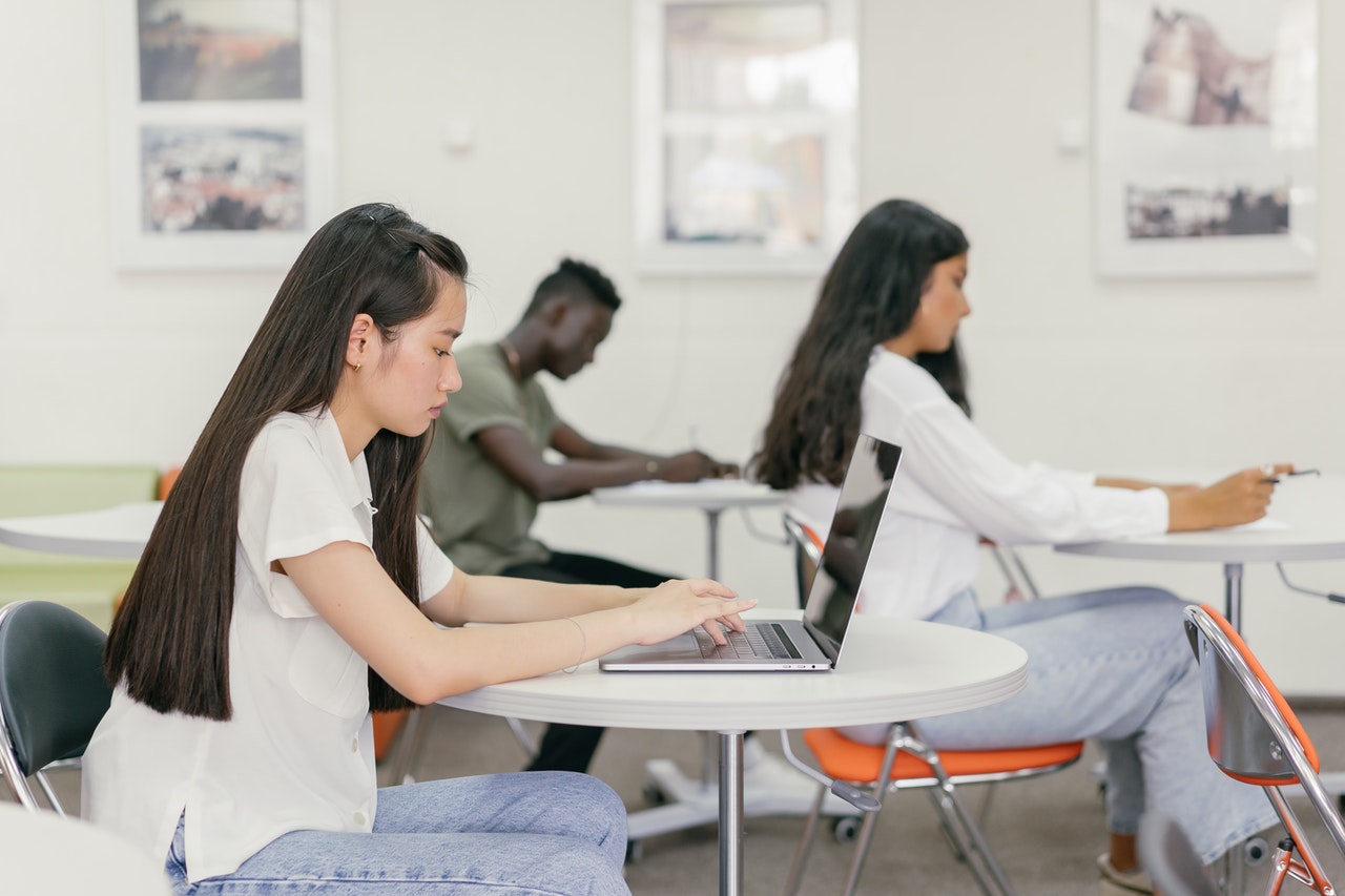 Trois lycéens et lycéennes dans une salle de classe