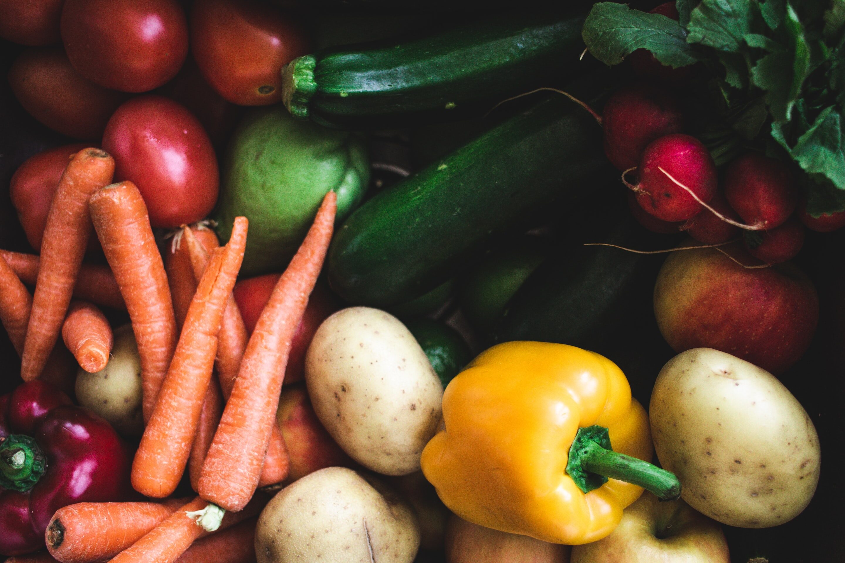 Vue en plongée de pommes de terre, poivrons, carottes, tomates et courgettes