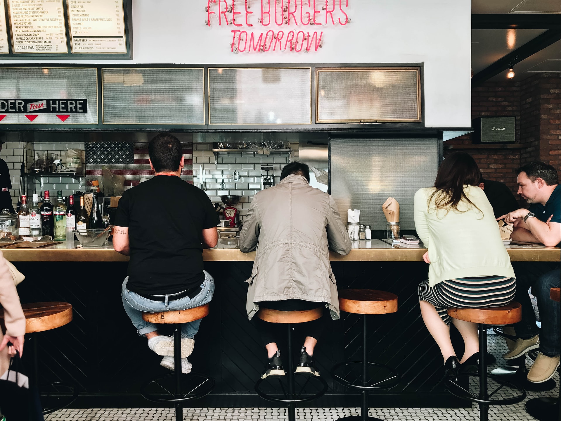 Quatre personnes assises au comptoir de restauration rapide