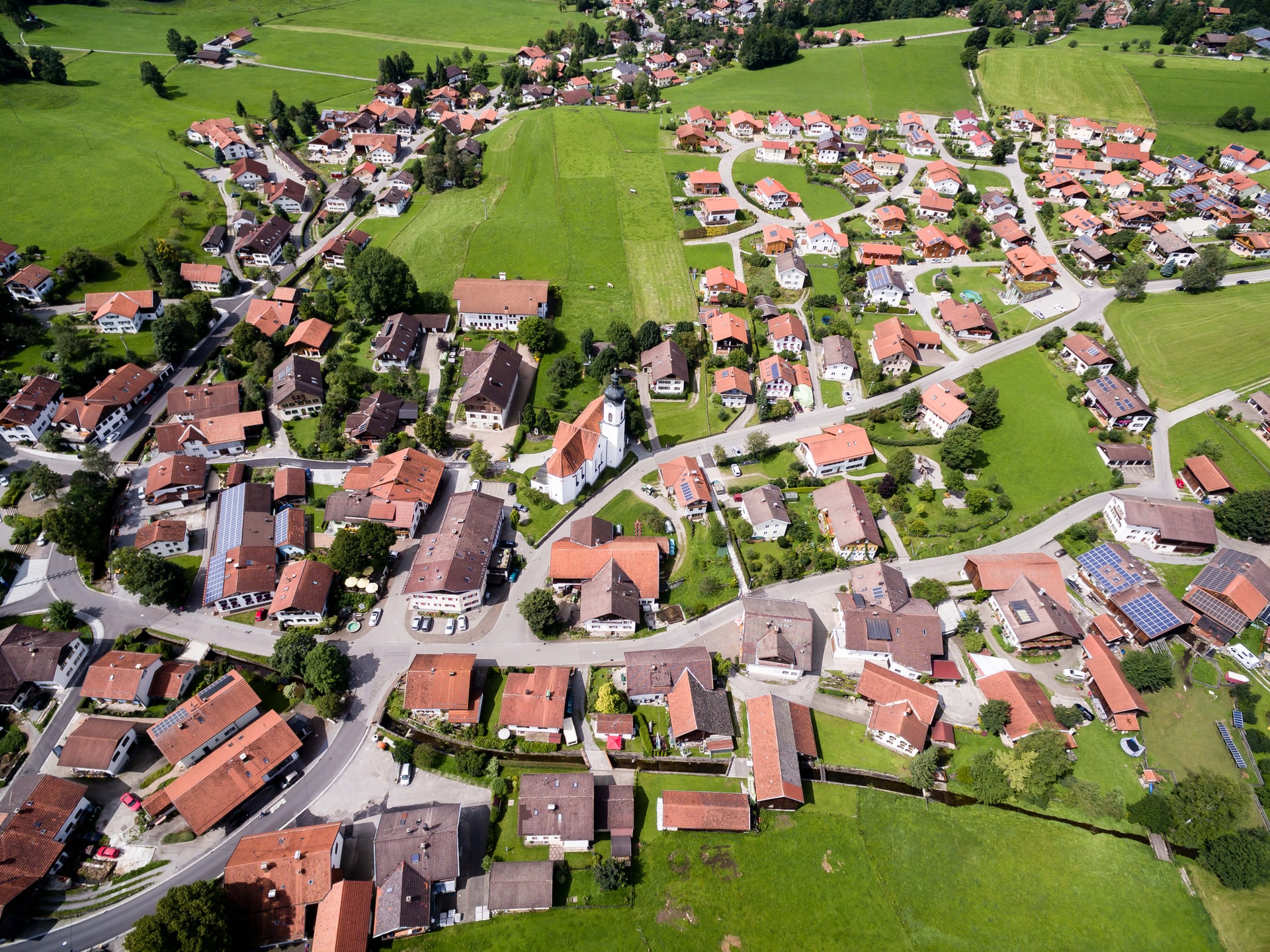 Vue aérienne d'un village de maisons aux toits en tuile entourées de champs