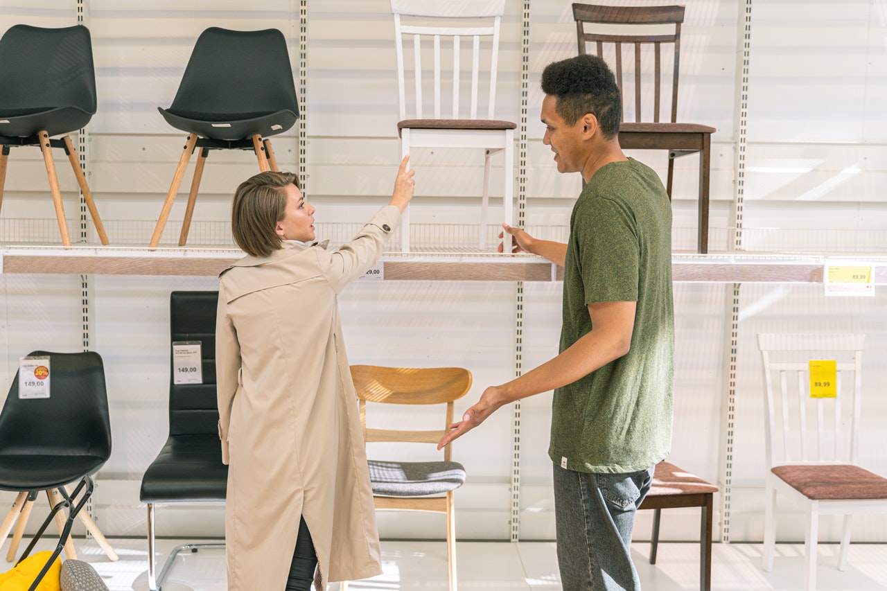 Dans un magasin de meubles un homme et une femme choisissent des chaises