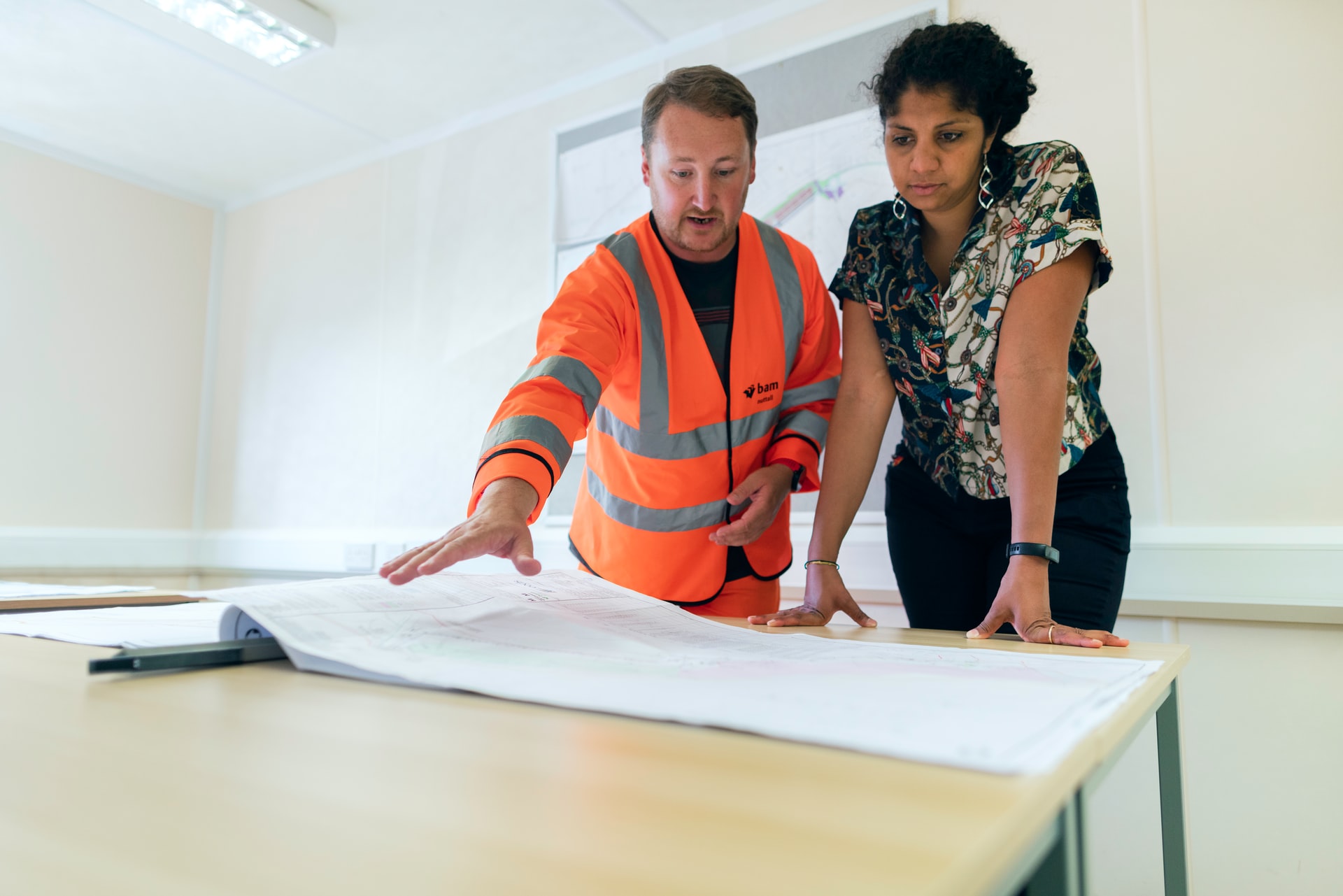 Une femme et un homme regardent un plan sur une table