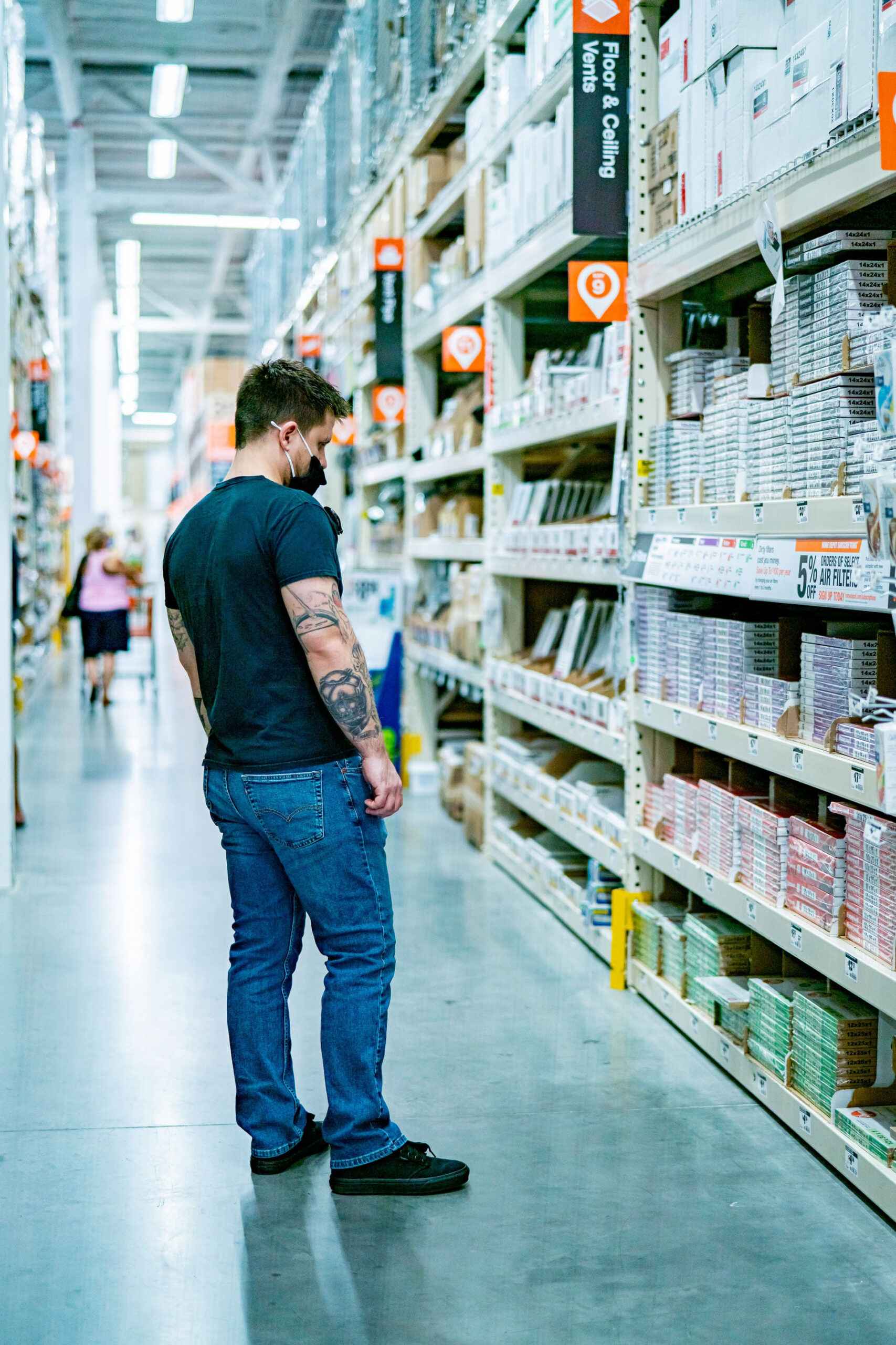 Un homme blanc debout dans une allée d'un magasin de bricolage