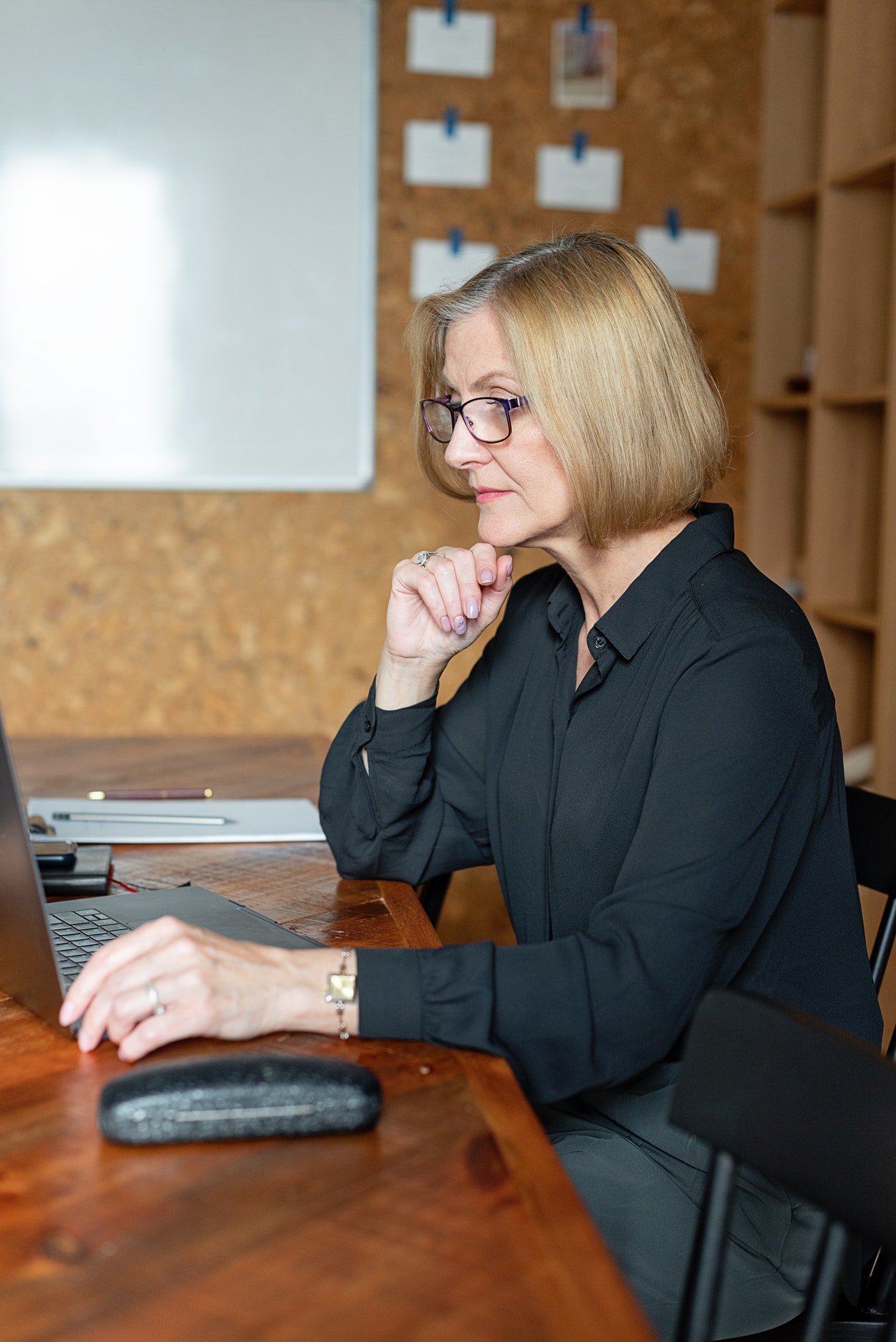 Une femme assise à son bureau regarde son ordinateur portable