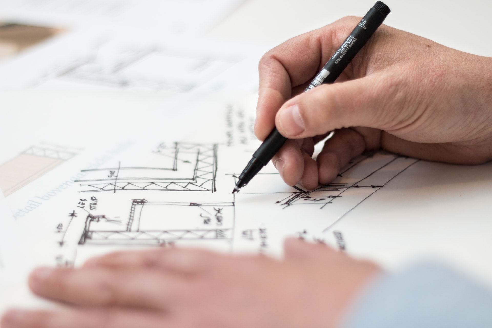 Gros plan sur les mains d'une personne dessinant un plan