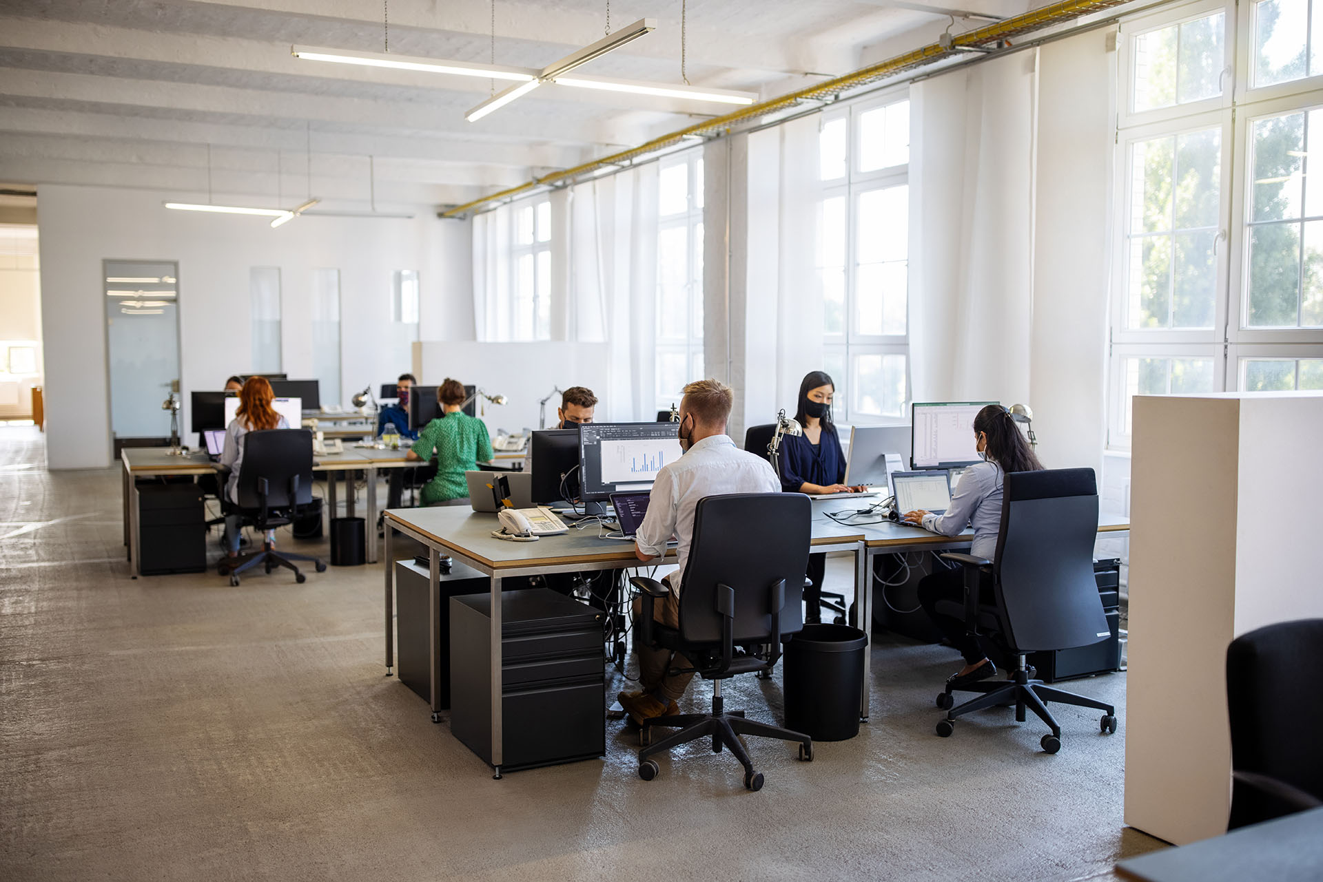 Personnes portant des masques travaillant dans un bureau