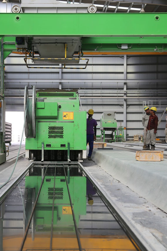 Un homme debout à côté d'uachine industrielle verte dans une usine
