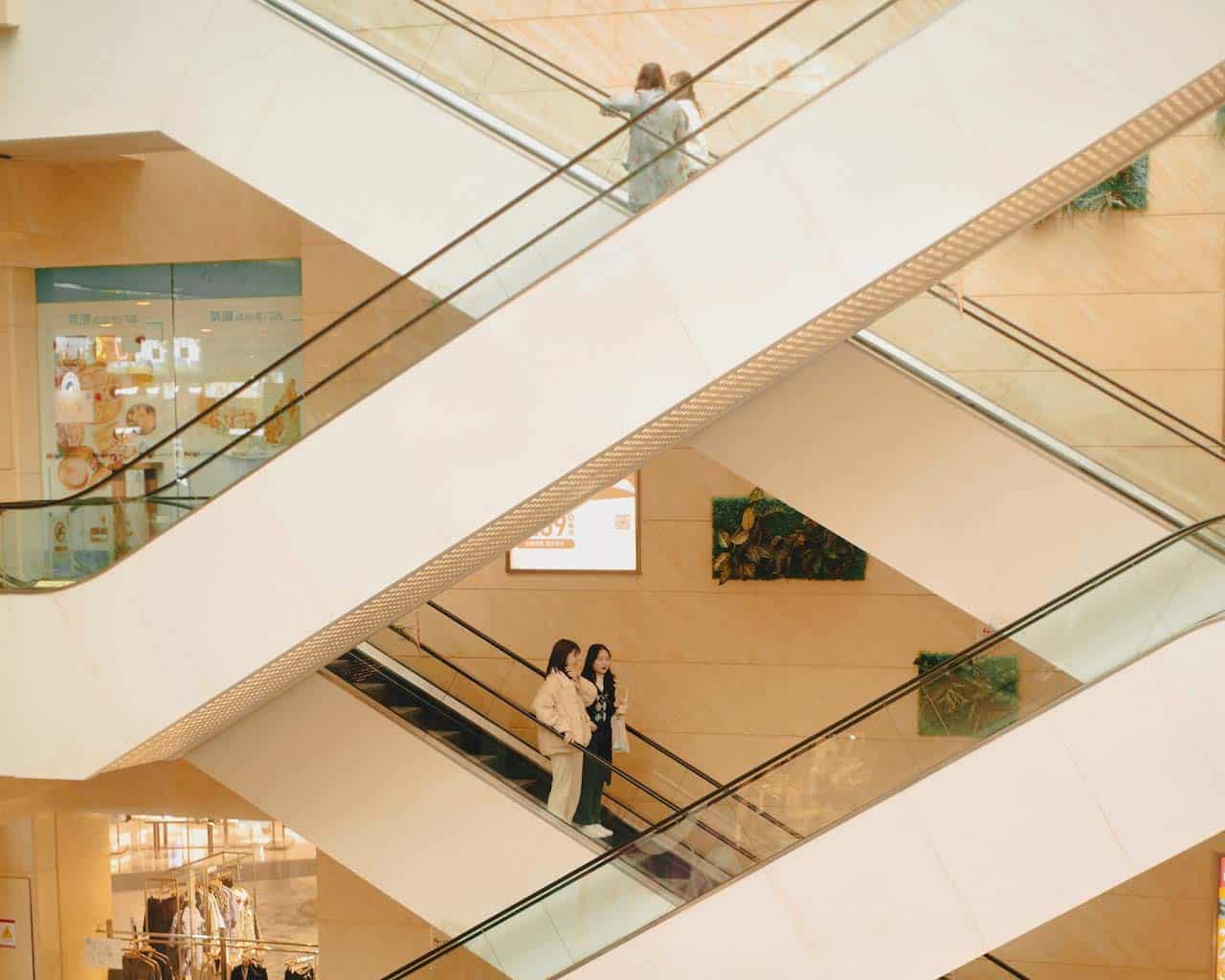 Personnes dans un escalier mécanique dans un centre commercial