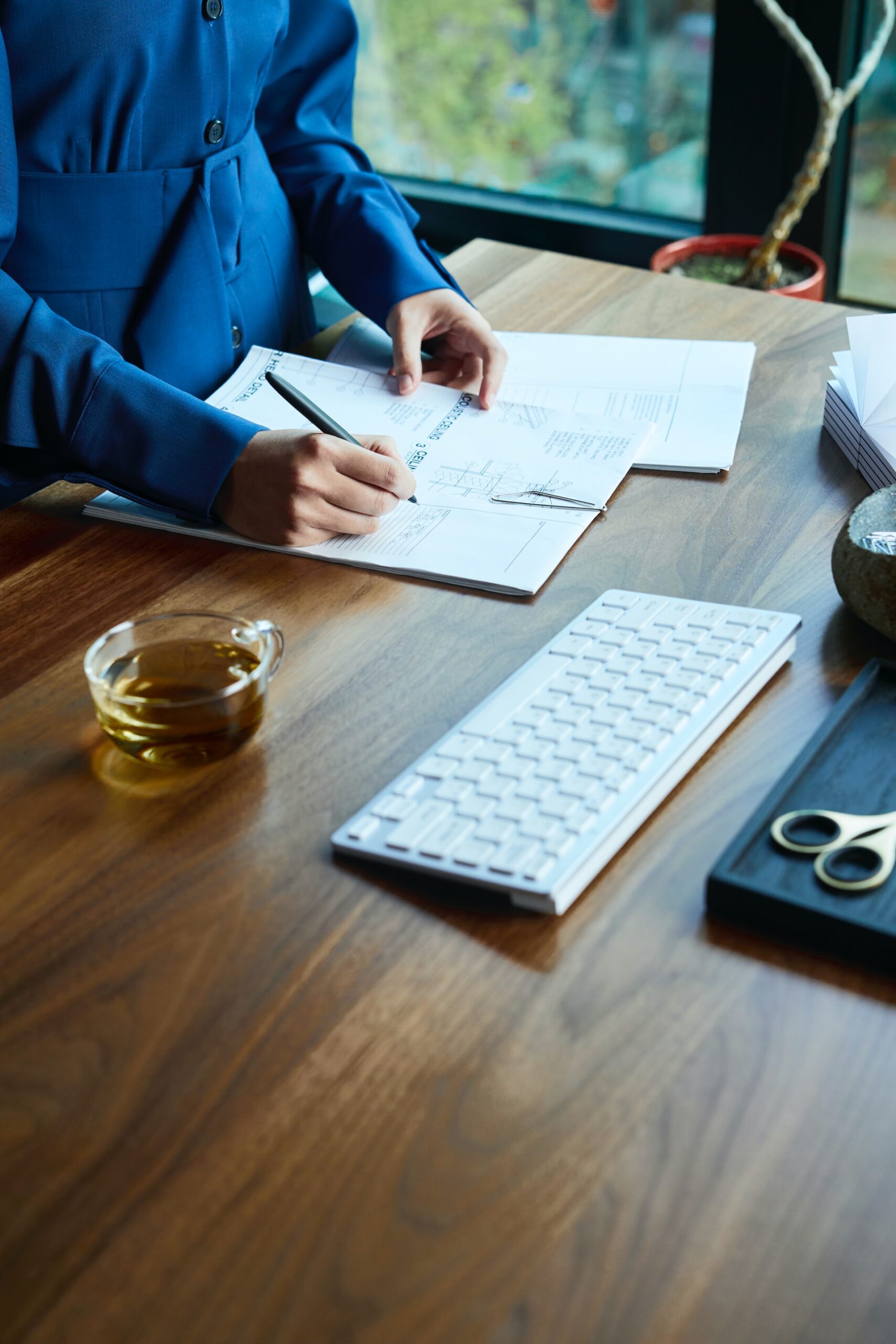 Mains d'une personne écrivant sur un document sur un bureau