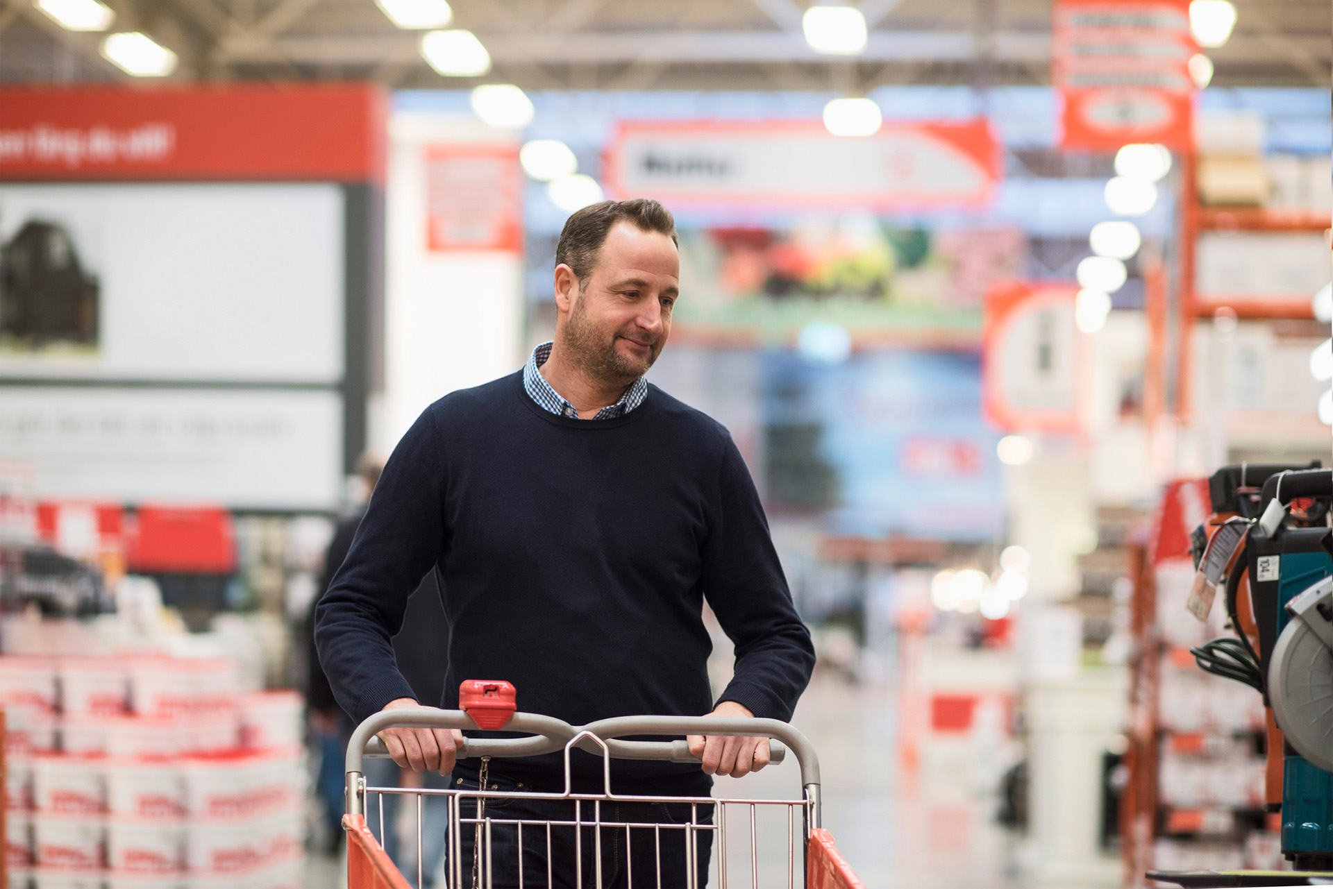 Un homme blanc d'âge moyen dans les rayons d'un supermarché pousse un chariot